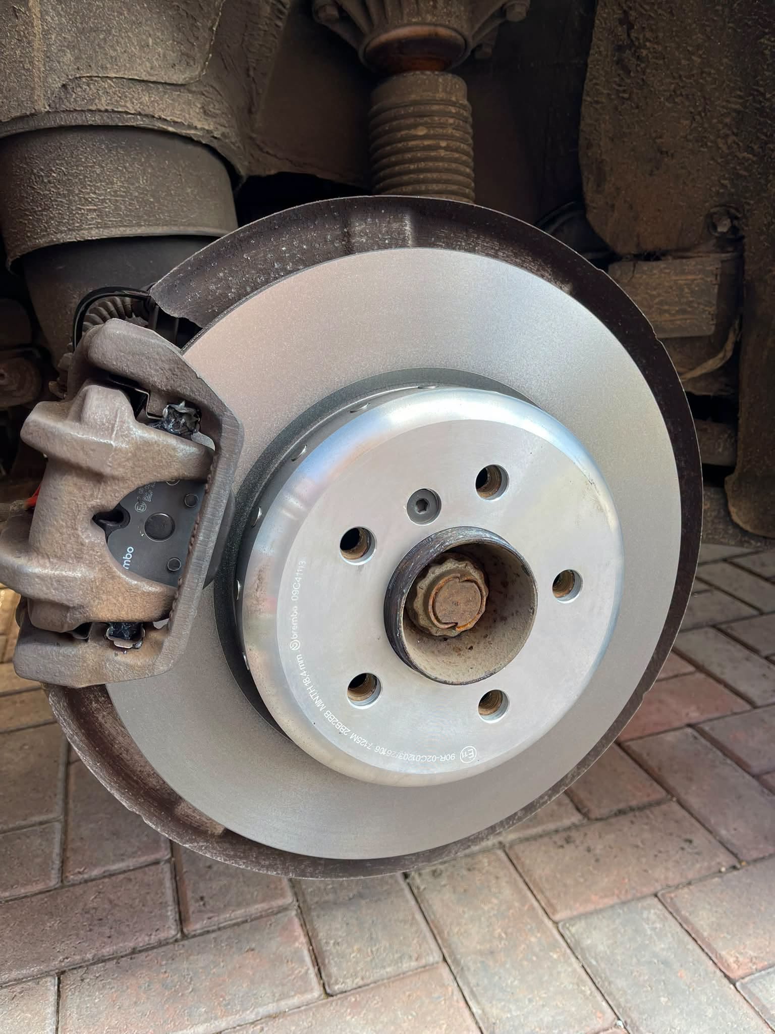 A new brake disc and caliper fitted with the wheel off