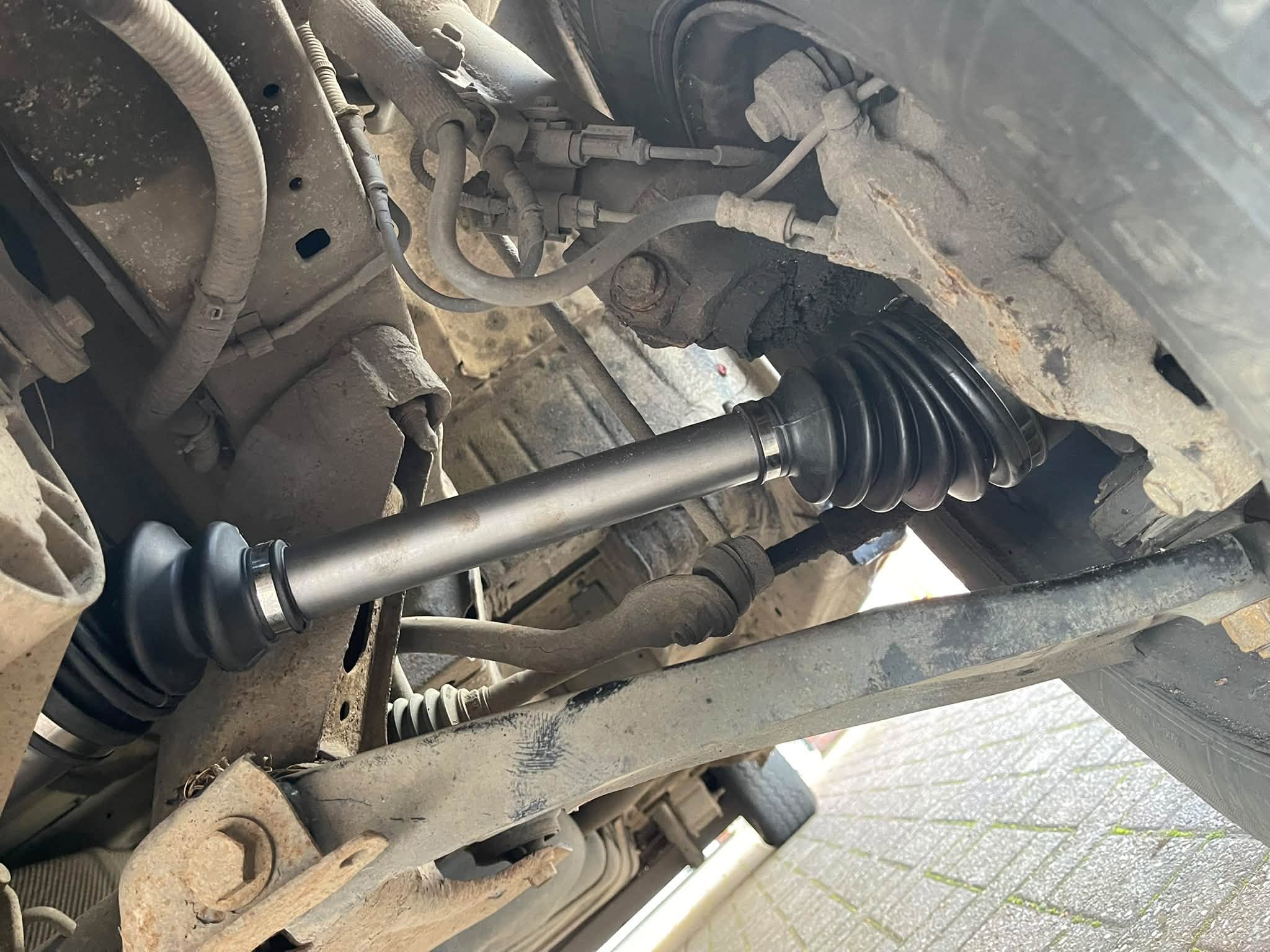 A new drive shaft and boot seen from under the car